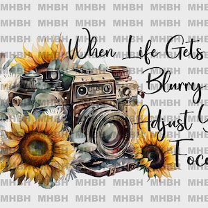 May include: Watercolor illustration featuring a vintage camera surrounded by sunflowers and greenery. The image includes the text "When Life Gets Blurry Adjust Your Focus". The design has a rustic, artistic aesthetic.