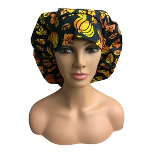 May include: A black scrub cap with a pattern of orange and yellow pumpkins and leaves.