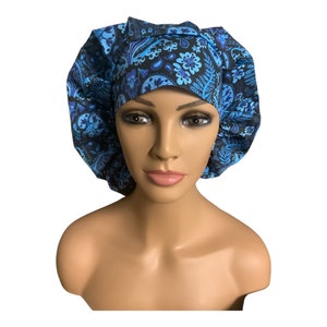 May include: A blue and black patterned surgical scrub hat with a gathered top. The hat has a paisley design with blue and black floral accents.