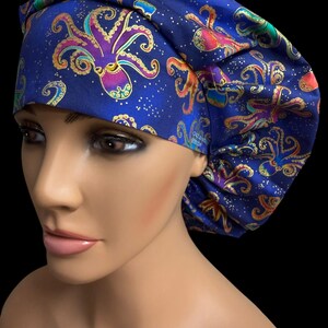 May include: A blue surgical scrub cap featuring a repeating pattern of colorful octopuses and gold accents. The octopus designs are in shades of purple, pink, orange, and green. The cap is made of a soft, flexible fabric.
