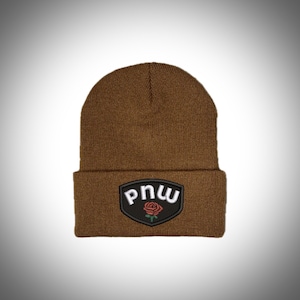 May include: A brown knit beanie with a black patch featuring a white "PNW" logo and a red rose.