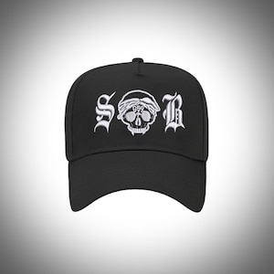 May include: Black baseball cap with a white embroidered skull and the letters "S.O.B." above it.