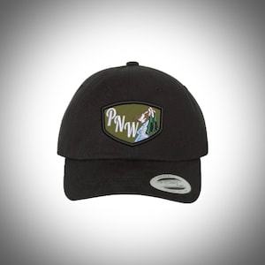 May include: Black baseball cap with a green, white, and blue embroidered patch that says "PNW" and depicts a mountain range.