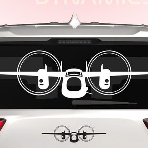 May include: White silhouette of a plane with propellers on a white car's rear window. The car has a Dingo Dynamics logo on the back.