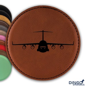 May include: A brown leather coaster with a black silhouette of a C-17 Globemaster III aircraft.