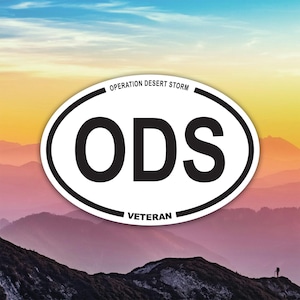 Puede incluir: Adhesivo ovalado con el texto "ODS" en letras negras en negrita. El adhesivo tiene un fondo blanco con un borde negro. Las palabras "OPERATION DESERT STORM" y "VETERAN" están impresas encima y debajo de las letras.