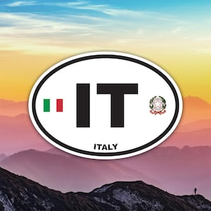Peut inclure: Un autocollant ovale à bordure blanche présente les lettres "IT" en noir, avec les couleurs du drapeau italien à gauche et un blason à droite. Le mot "ITALY" est imprimé en dessous.