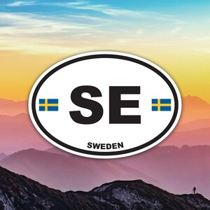 Peut inclure: Autocollant ovale avec un fond blanc, une bordure noire et les lettres "SE" en noir. Le drapeau suédois est de chaque côté des lettres. Le mot "SWEDEN" est imprimé en dessous. L'arrière-plan montre une chaîne de montagnes.