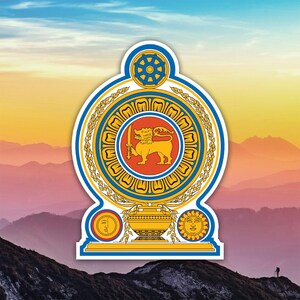 May include: A sticker depicting the Sri Lankan coat of arms. It features a golden lion with a sword, within a blue and gold border. The background shows a mountain range under a colorful sky.