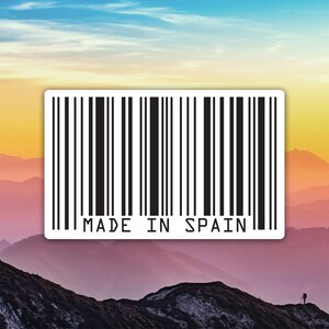 Könnte beinhalten: Ein weißer Aufkleber mit einem schwarzen Barcode-Design und dem Text "MADE IN SPAIN". Der Aufkleber befindet sich vor einem Hintergrund aus Bergen und einem farbenfrohen Himmel.