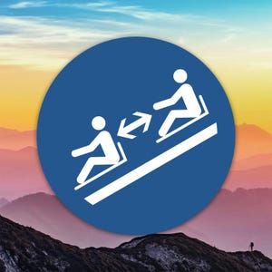 May include: A blue circular sign featuring white figures seated on a moving walkway, with arrows indicating direction. The background shows a mountain range under a colorful sky.