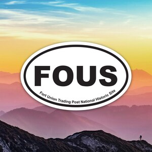 Puede incluir: Una pegatina ovalada con la palabra "FOUS" en negrita negra. Debajo, el texto "Fort Union Trading Post National Historic Site". La pegatina está sobre un fondo de montañas y un cielo colorido.