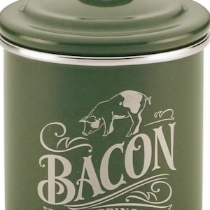 May include: A green enamelware container with a lid and handle, designed for bacon drippings. The container features a pig illustration and the word "BACON" in a decorative font, with "DRIPPINGS" below.