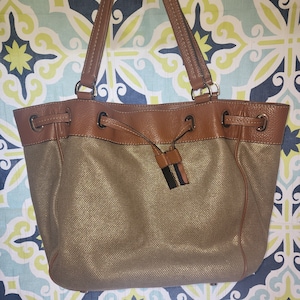 Monedero vintage Michael Kors metalizado dorado con cordón de cuero, 2 asas y cierre a presión