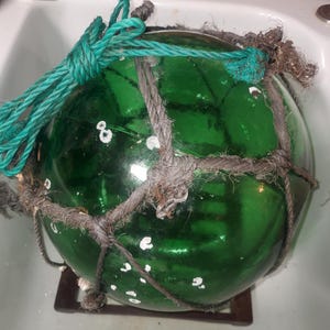 Grande e autêntico bóia de rede de pesca vintage feita à mão em vidro verde e corda trançada