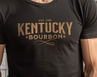 May include: A black t-shirt with a gold graphic print that reads "EST. 1789 KENTUCKY *BOURBON*"