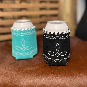 Pu&ograve; includere: Due porta-lattine, uno turchese e uno nero, ciascuno con cuciture decorative bianche. I porta-lattine hanno un bordo bianco sul bordo superiore e un motivo decorativo cucito sul davanti. Progettati per contenere una lattina standard.
