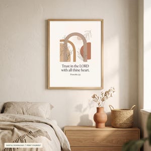 Puede incluir: Una lámina de arte mural enmarcada con un diseño abstracto de arcos y dibujos botánicos de líneas en tonos beige, tostado y terracota. El texto dice: Trust in the LORD with all thine heart. Proverbs 3:5. La lámina tiene un marco de madera clara.