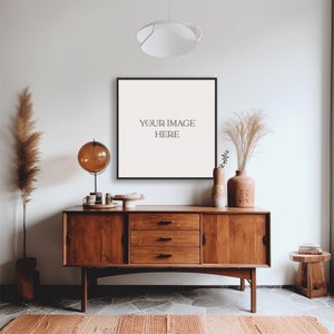 May include: A mid-century modern wooden dresser with three drawers, a black framed picture with the text "YOUR IMAGE HERE", a globe lamp, and dried pampas grass in a terracotta vase.