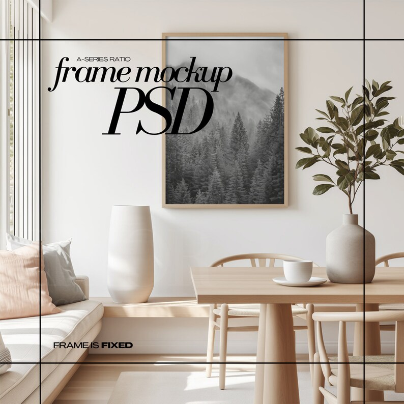 Op de afbeelding: Een ingelijste zwart-witfoto van een bos hangt aan een witte muur boven een houten tafel met twee stoelen. Een vaas met een groene plant staat op de tafel. De tekst "frame mockup PSD" staat op de muur.