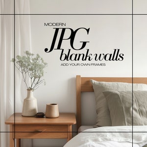 May include: A white wall with the text "MODERN JPG blank walls ADD YOUR OWN FRAMES" in black. A wooden nightstand with a vase of white flowers and a brown mug on top. A bed with a white duvet and a green pillow is in the background.