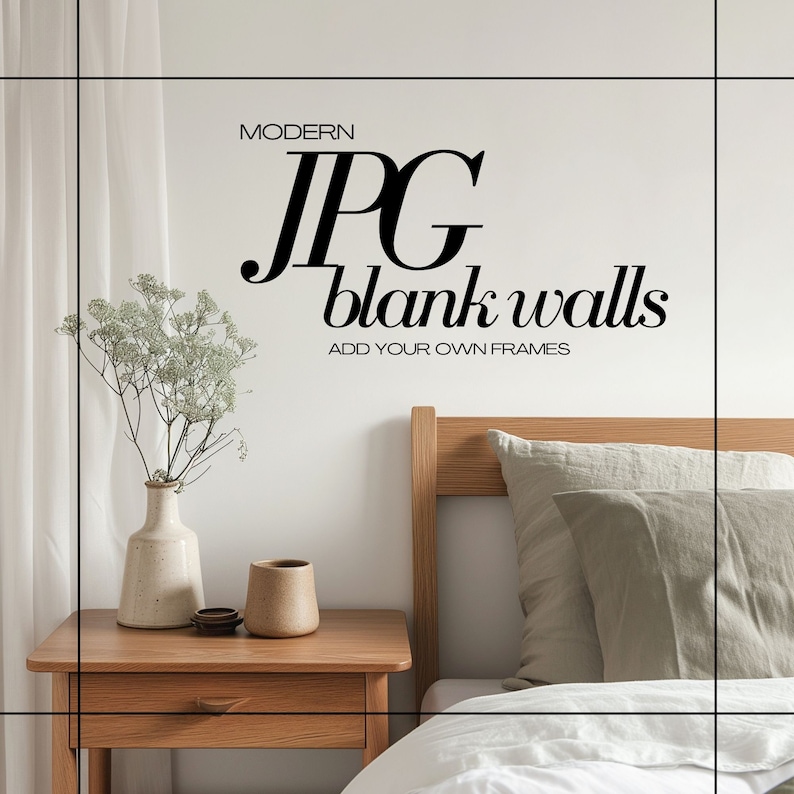 May include: A white wall with the text "MODERN JPG blank walls ADD YOUR OWN FRAMES" in black. A wooden nightstand with a vase of white flowers and a brown mug on top. A bed with a white duvet and a green pillow is in the background.