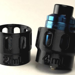 May include: Two black plastic vape tank sleeves, one labeled "2ml" and the other "4ml".