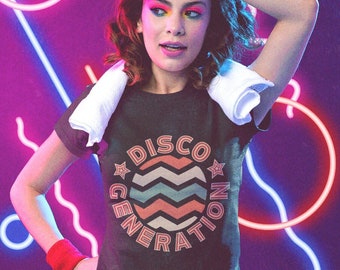 May include: Dark gray t-shirt with the text "DISCO GENERATION" in a circular design with a retro wave pattern. The model is wearing red shorts and wristbands, with a white towel around the neck. Neon lights in the background.