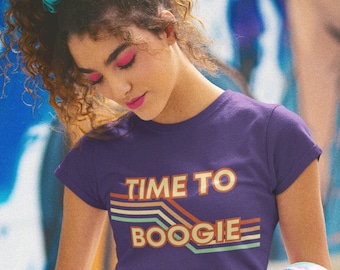 May include: A woman wearing a purple t-shirt with the text "TIME TO BOOGIE" in a retro font and a blue denim skirt. She is holding a silver boombox with a cassette tape inserted.