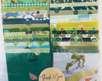 May include: A selection of green fabric squares in diverse patterns, such as stripes, florals, and geometric shapes. A round sticker with the words "Thank You" is visible. The fabric squares are packaged in a clear plastic bag.