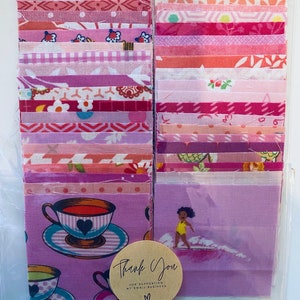 Peut inclure: Un ensemble de 20 carrés de tissu rose et rouge dans un sac en plastique transparent. Les carrés de tissu sont disposés en deux colonnes. Les carrés présentent divers motifs, notamment floraux, géométriques et à pois. Une petite étiquette brune avec le texte "Merci de soutenir ma petite entreprise" est attachée au sac.