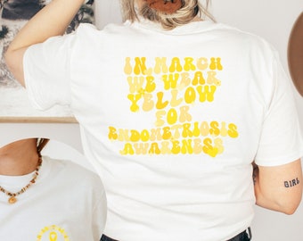 May include: White t-shirt with a yellow graphic that reads "In March We Wear Yellow for Endometriosis Awareness".