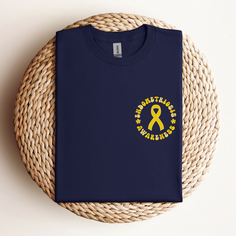 May include: A navy blue t-shirt with a yellow ribbon and the text "Endometriosis Awareness" in a circle.