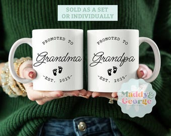 May include: Two white ceramic mugs with black text and a footprint design. The mug on the left says "Promoted to Grandma - Est. 2025" and the mug on the right says "Promoted to Grandpa - Est. 2025".