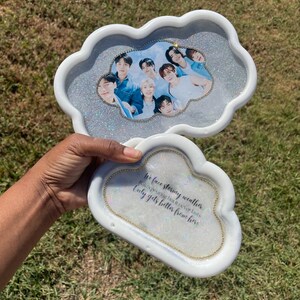 May include: A white cloud-shaped tray with a glitter finish and a photo of a group of people inside. The tray has a quote on the bottom that reads "We face stormy weather, just remember that it never lasts, only gets better from here."