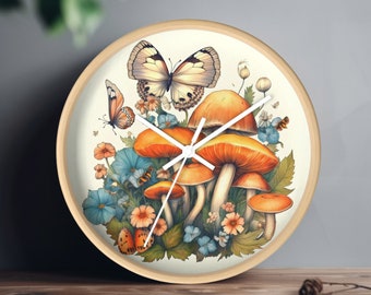 Könnte beinhalten: Eine runde Holzuhr mit weißem Zifferblatt und schwarzen Zeigern. Die Uhr zeigt ein fantasievolles Design mit orangefarbenen Pilzen, grünen Blättern und einem weißen Schmetterling.