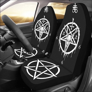 May include: A set of two black car seat covers with a white pentagram and goat head design. The covers feature the text "666" and a symbol resembling an upside-down cross.