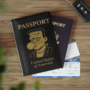 May include: Black passport cover with gold lettering that reads "PASSPORT" and "United States of America." The cover features a cartoon image of Frankenstein blowing a bubble. A dark blue passport and two boarding passes are also visible.