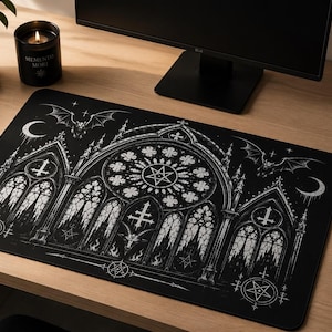 May include: Black rectangular mousepad featuring a gothic cathedral design with a large rose window, inverted crosses, and bats. The design is in white against a black background. The mousepad is on a wooden desk.
