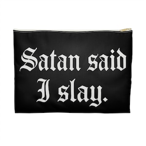 Op de afbeelding: Zwarte etui met ritssluiting met de tekst "Satan said I slay" in witte gotische letters. De etui heeft een goudkleurige ritssluiting en een witte naad. De achtergrond is zwart.
