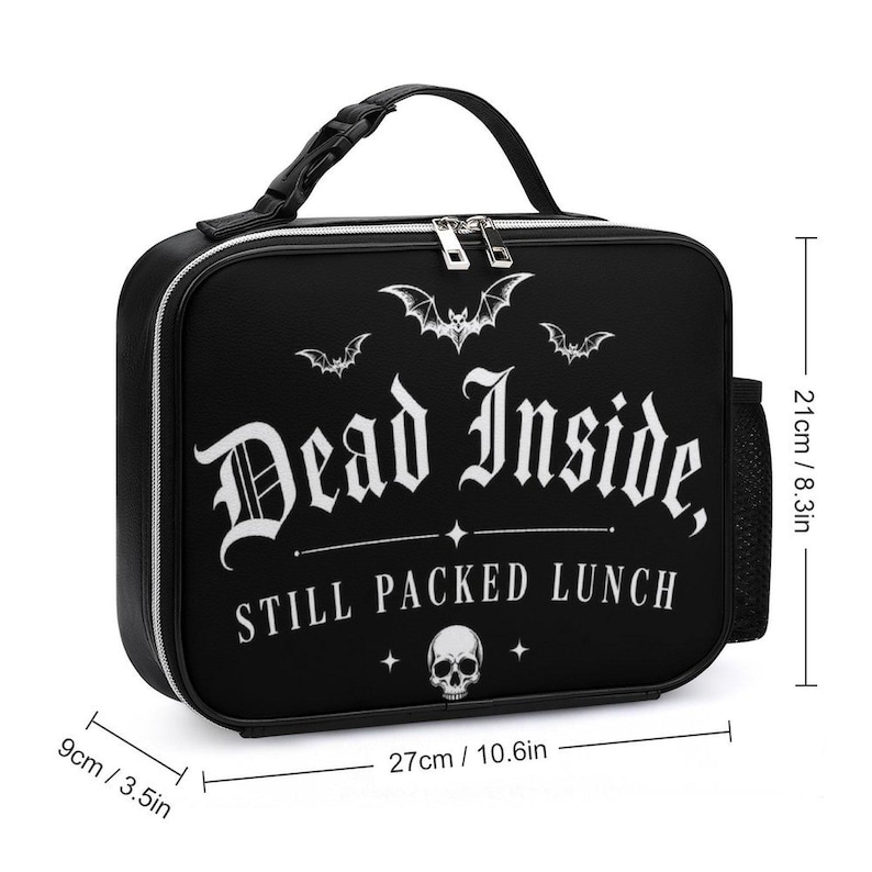 Pu&ograve; includere: Borsa per il pranzo nera con la scritta "Dead Inside, Still Packed Lunch" in bianco. La borsa ha un manico nero, cerniera e tasca laterale. Dimensioni: 27 cm di larghezza, 21 cm di altezza e 9 cm di profondit&agrave;.