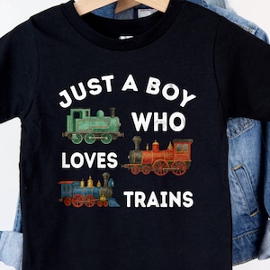 May include: Black t-shirt with the text "Just a boy who loves trains" in white. Three cartoon trains are pictured below the text.