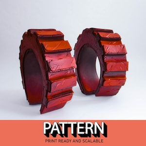 May include: Two red 3D printed rings with a textured surface. The rings are stacked on top of each other.
