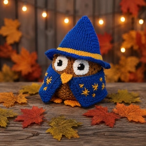 Peut inclure: Une figurine de chouette crochetée marron portant un chapeau de magicien bleu avec une bande jaune et une cape bleue assortie ornée d'étoiles jaunes brodées. La chouette a de grands yeux blancs à pupilles noires, un bec et des pattes orange.