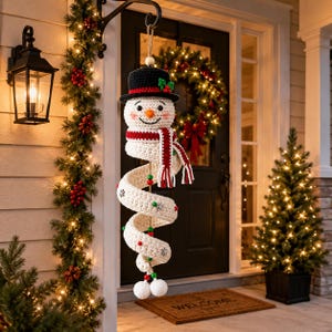 Peut inclure: Une décoration suspendue en forme de bonhomme de neige au crochet, dotée d'un chapeau noir avec du houx, d'un nez orange et d'une écharpe rayée rouge et blanche. Le corps est une longue spirale blanche ornée de perles rouges et vertes et de flocons.