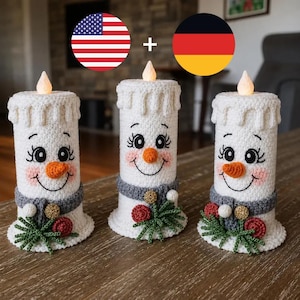 May include: Three white crocheted candle figures with orange carrot noses, black embroidered eyes, and pink cheeks. Each figure wears a grey scarf with small red and gold accents and green foliage. A small glowing light sits atop each candle.
