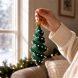 May include: A dark green crocheted Christmas tree ornament featuring a spiral design with small white beads attached to the edges. The tree is topped with a small yellow crocheted star and hangs from a thin string loop for display purposes.