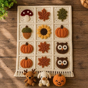 Peut inclure: Une tenture murale rectangulaire en crochet couleur crème composée de douze carrés avec des appliqués sur le thème de l'automne, dont des champignons, des feuilles, des glands, des tournesols, des citrouilles et des hiboux.