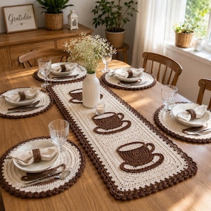 Peut inclure: Un chemin de table rectangulaire en crochet et quatre sets de table ronds assortis, de couleur crème et marron. Le chemin de table présente trois motifs de tasses à café marron. Chaque set inclut une serviette crème avec un rond de serviette.