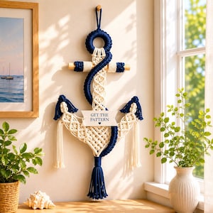 Peut inclure: Décoration murale en macramé en forme d'ancre, bleu marine et crème. Le décor sur le thème nautique comprend une barre transversale en bois et une pampille décorative. Le texte "GET THE PATTERN" est sur une petite bannière.